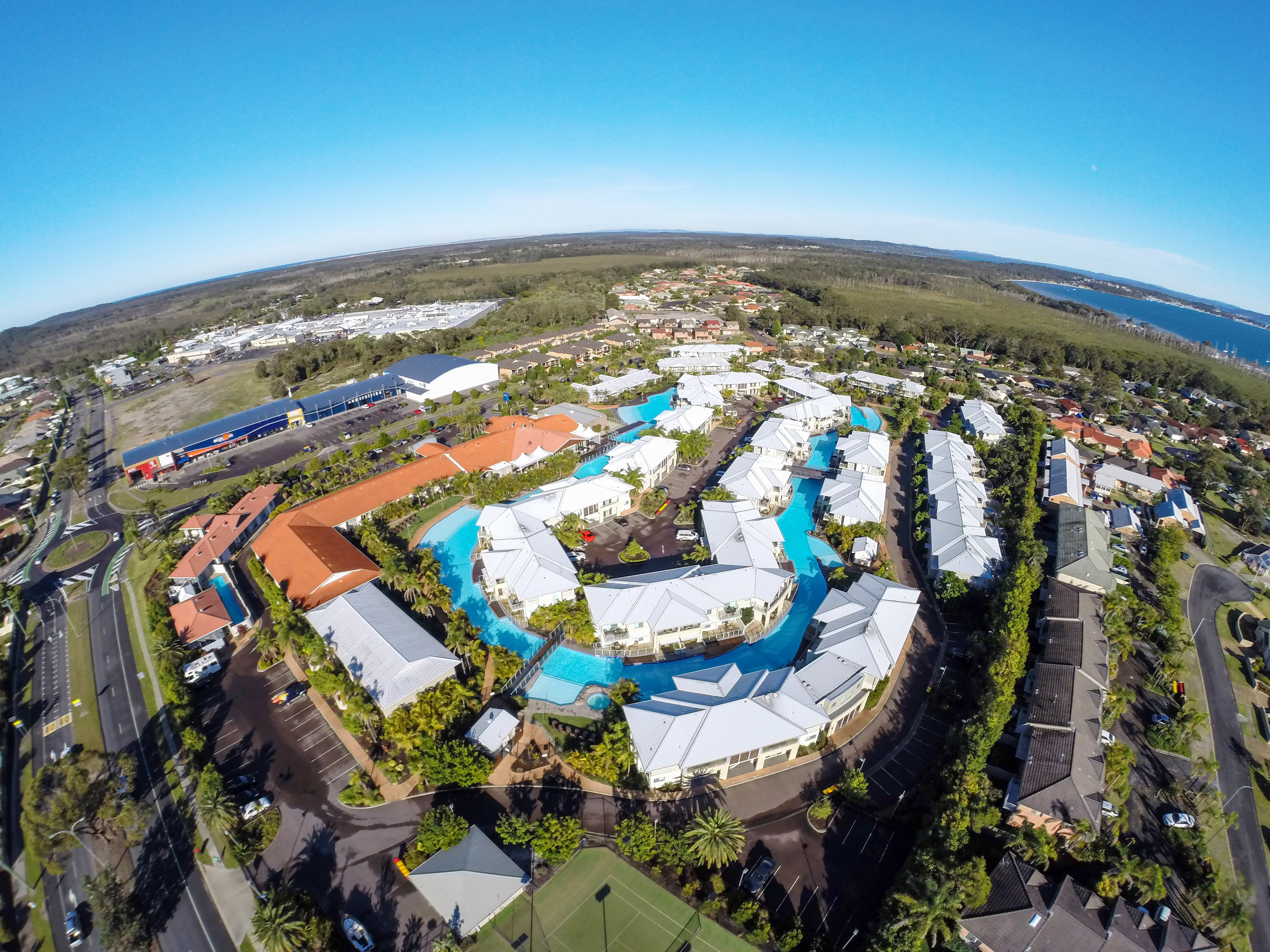 An aerial photo of the large lagoon pool surrounded by the villas at Oaks Port Stephens Pacific Blue Resort at Salamander Bay.