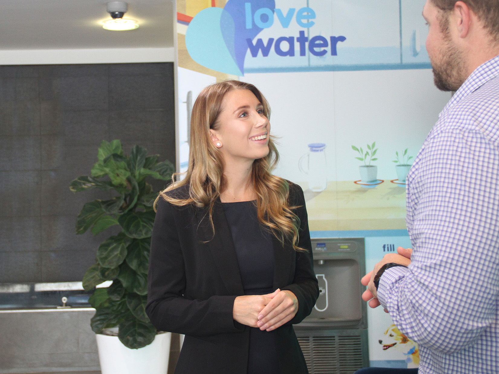 Image shows a customer speaking with someone from Hunter Water in an office environment.