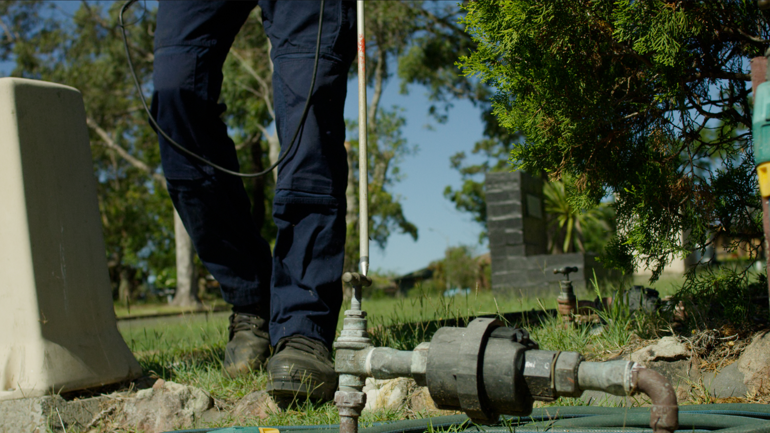 A meter reader approaching a water meter.